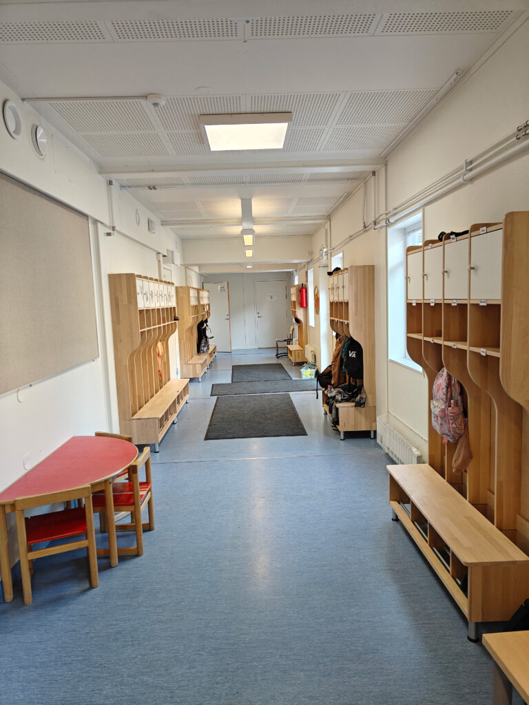 Koulun käytävä, jonka varrella on naulakkoelementtejä.